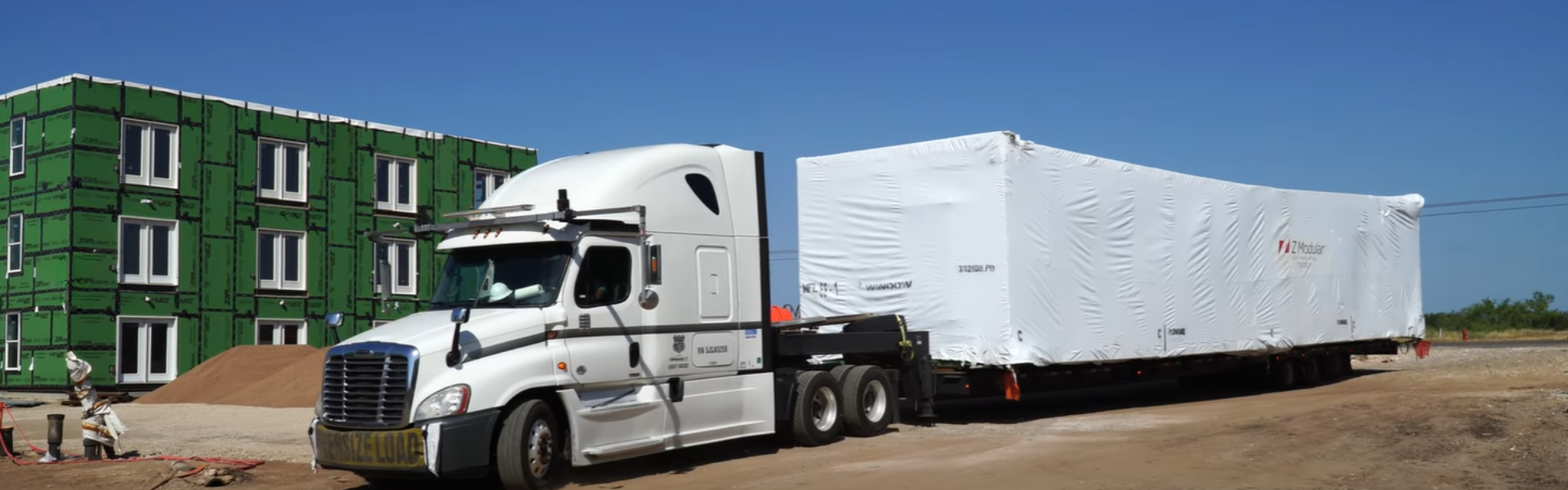 Modular building being delivered in sections and assembled as an office building